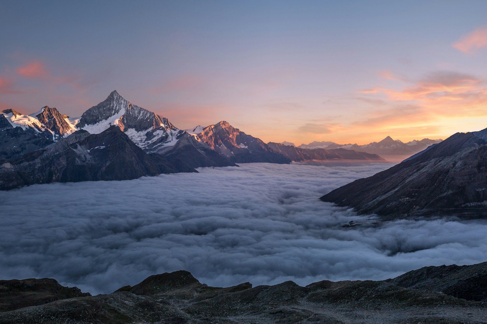 Alpine peaks at sunrise above a sea of cloud