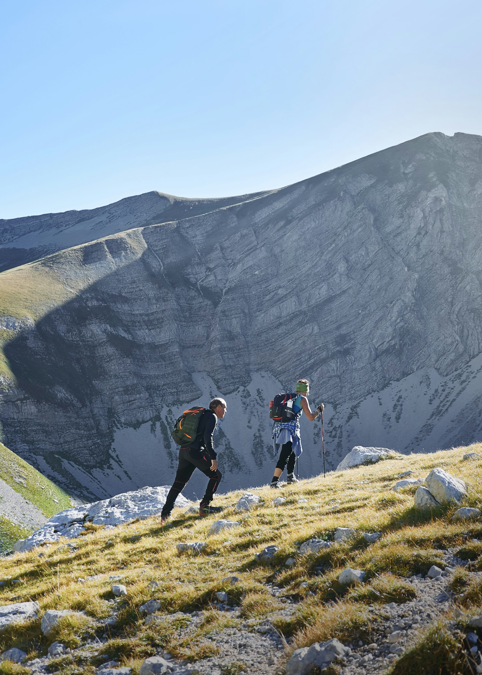 Hikers on a high mountain trail with peaks beyond